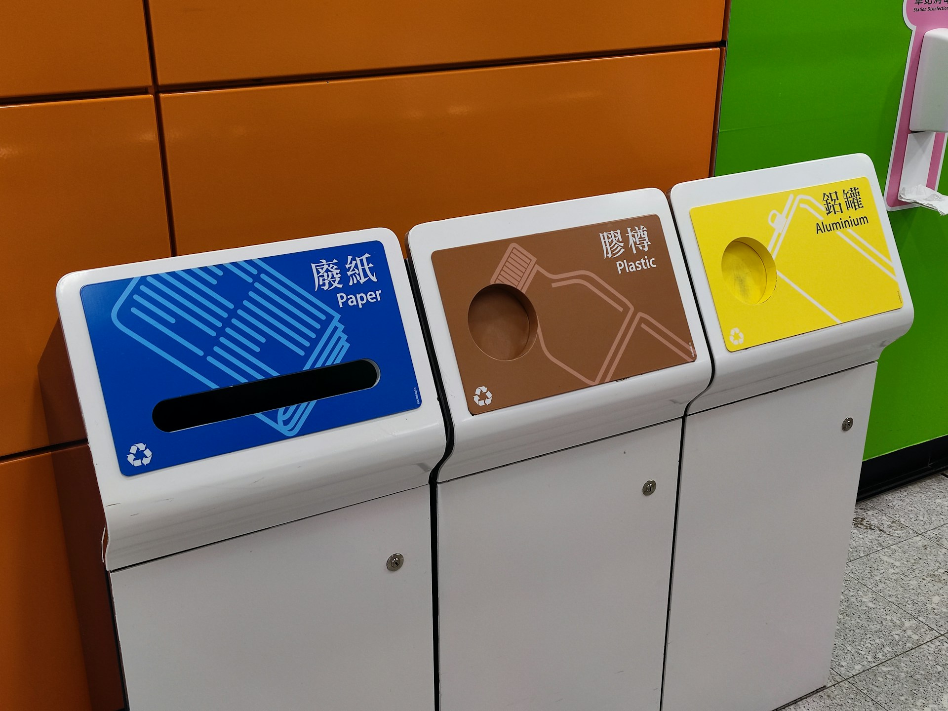 Recyclable waste materials like plastic bottles and cardboard being sorted at a recycling facility.